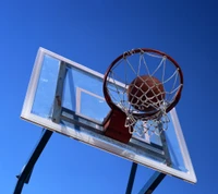 Baloncesto en la red bajo cielos azules claros