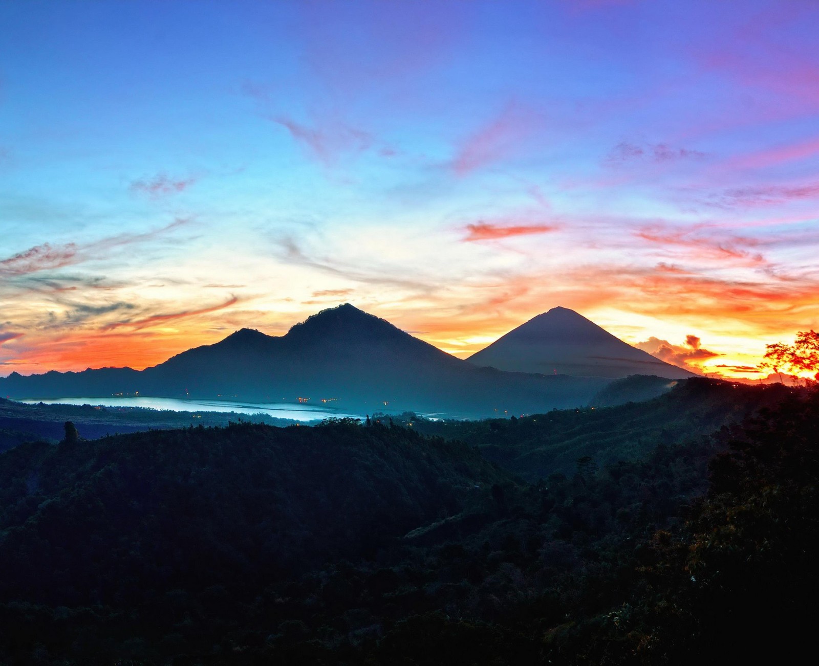 A view of a mountain range with a sunset in the background (bali, indonesia, kintamani, mountains, sky)