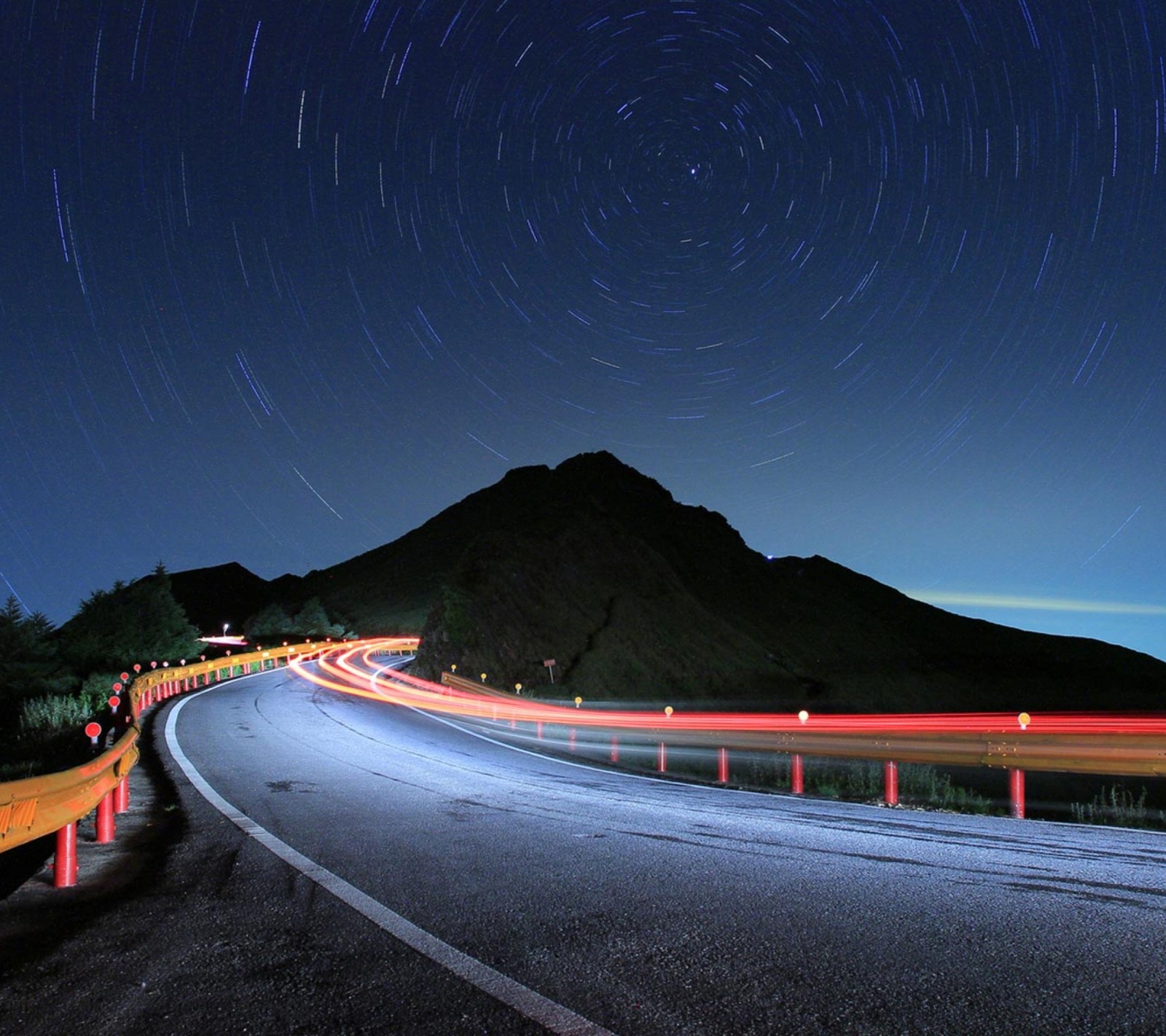 Photo de nuit d'une route sinueuse avec une montagne en arrière-plan (montagne, fonds décran nature, nuit, pluie, route)