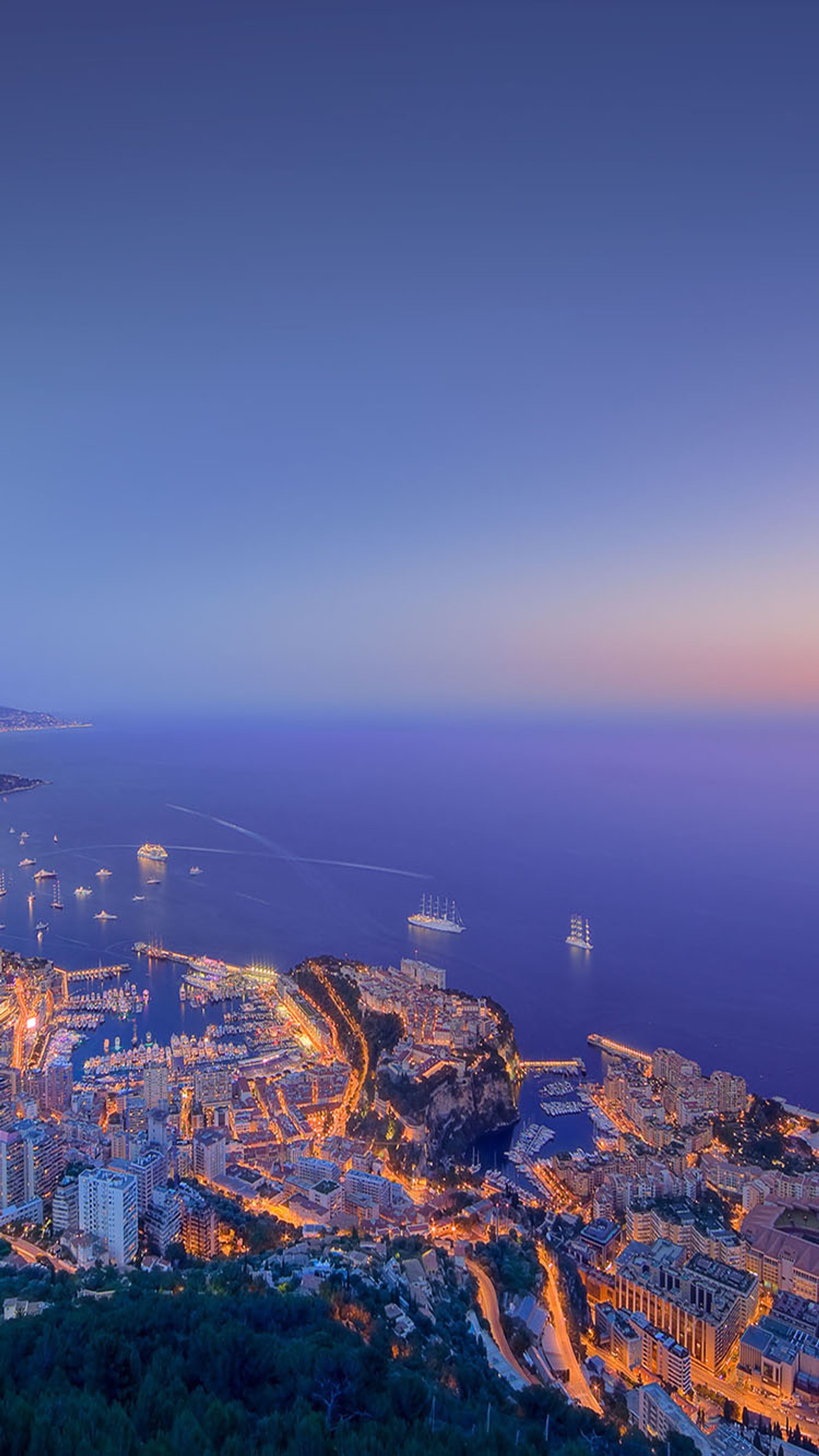 Vista aérea de uma cidade à noite com um barco na água (cidade, porto)