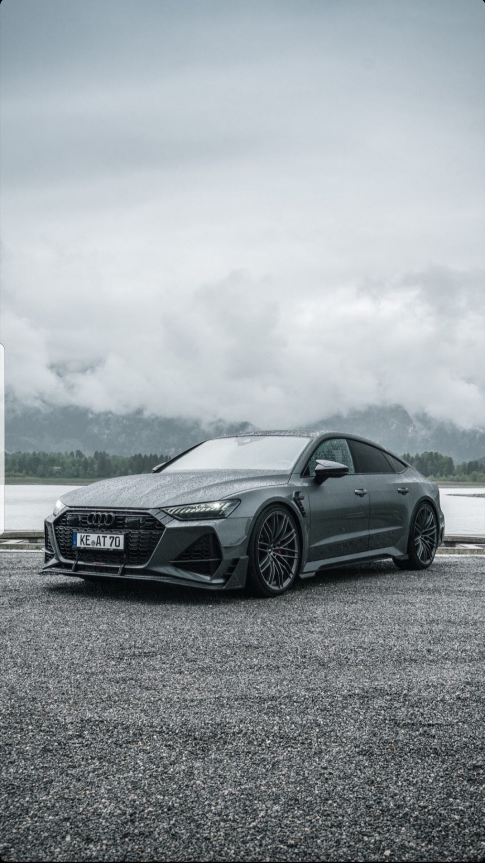 A close up of a car parked on a road near a body of water (abt, audi, black, car, cars)