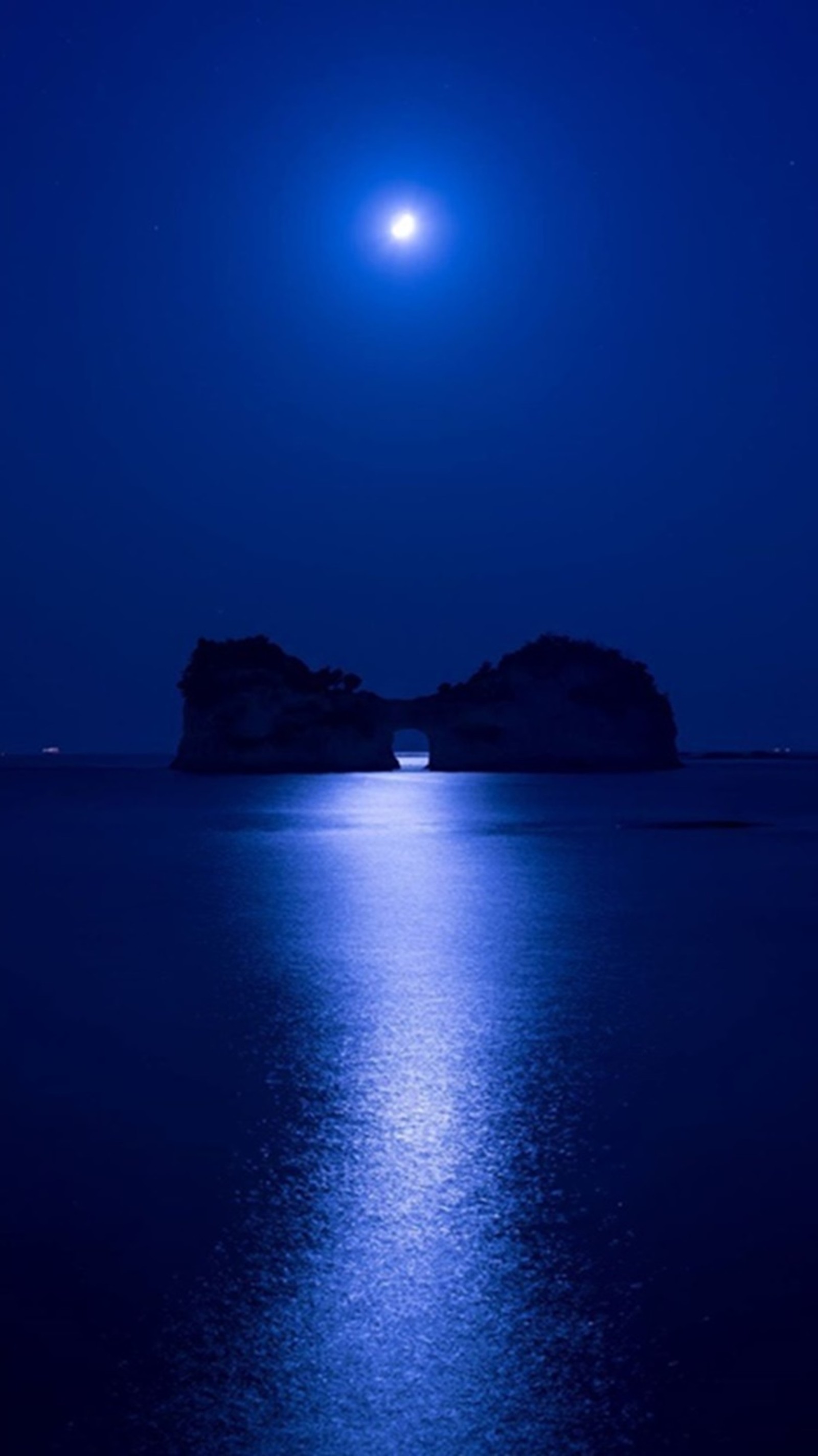 Una vista de la luna llena sobre el océano con un bote en el agua (noche azul profunda, naturaleza, océano)