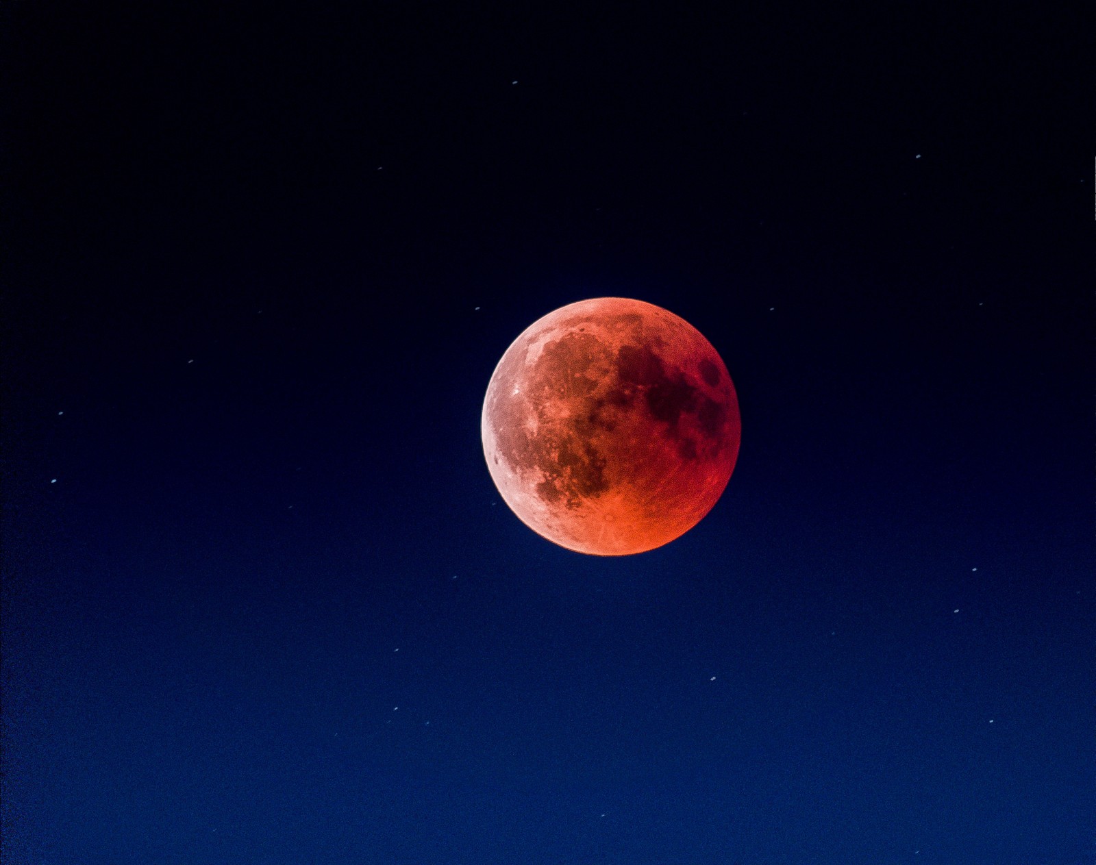 Image arafed d'une lune de sang avec un ciel bleu (éclipse lunaire, lune, éclipse, événement céleste, atmosphère)