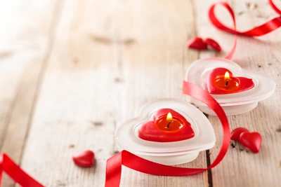 Velas en forma de corazón con cintas rojas y acentos dulces para celebraciones del Día de San Valentín