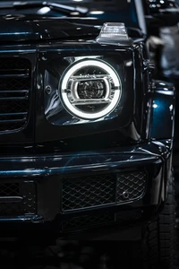 Rejilla frontal elegante y faros iluminados de un Mercedes-Benz G-Class