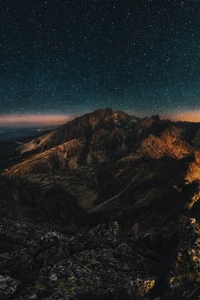 Paisagem montanhosa iluminada por estrelas ao crepúsculo