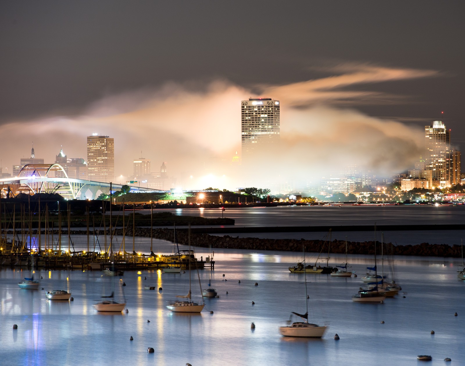 Barcos na água à noite com uma cidade ao fundo (paisagem urbana, reflexo, água, cidade, noite)