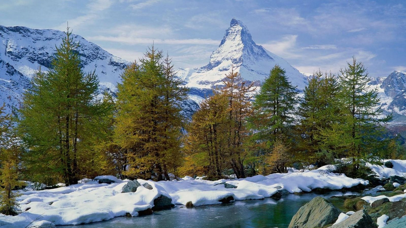 Mountains covered in snow and trees next to a river (tree, nature, mountain, wilderness, mountainous landforms)