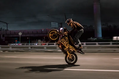 Realizador de acrobacias en moto haciendo wheelie nocturno en acción