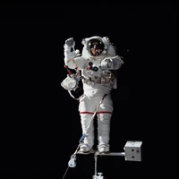 Astronaute en combinaison spatiale effectuant une sortie dans l'espace à l'extérieur de la Station spatiale internationale, explorant l'immensité de l'espace.