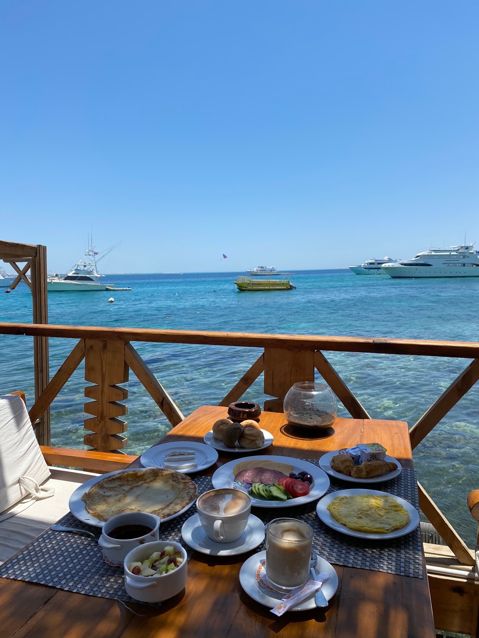 Há uma mesa com pratos de comida no convés (mar, utensílios de servir, pratos, embarcação, cozinha)