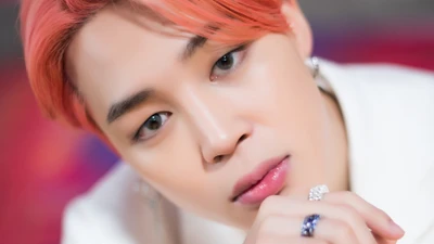 Jimin do BTS com um olhar cativante e cabelo laranja estiloso.