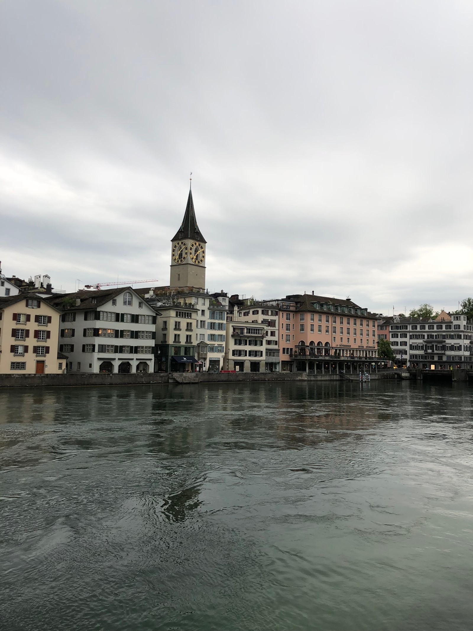 Edificios a lo largo del río con una torre del reloj en el medio (café, recursos hídricos, arquitectura, vía fluvial, fachada)