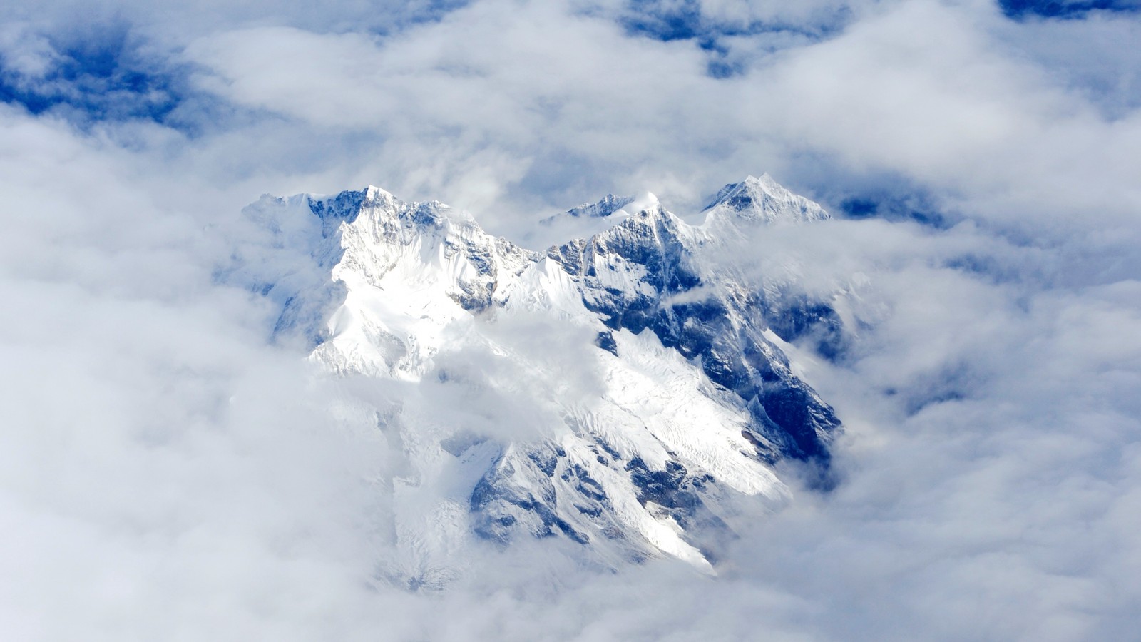 Montagne arabe dans les nuages avec un avion survolant (chaîne de montagnes, formes montagneuses, nuage, neige, nunatak)