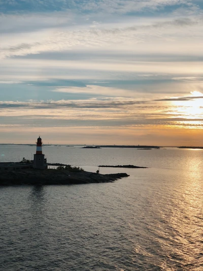 Phare au coucher du soleil : Un phare surplombant des eaux sereines