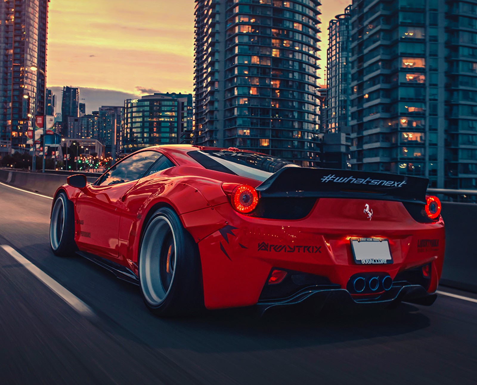 Ferrari car driving on a city street at night with skyscrapers in the background (458, car, cars, ferrari, red)