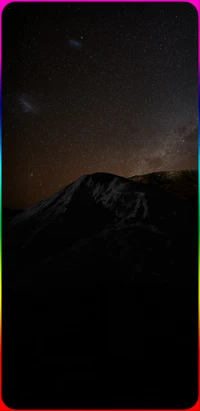 Montaña estrellada con nebulosa y borde de arcoíris