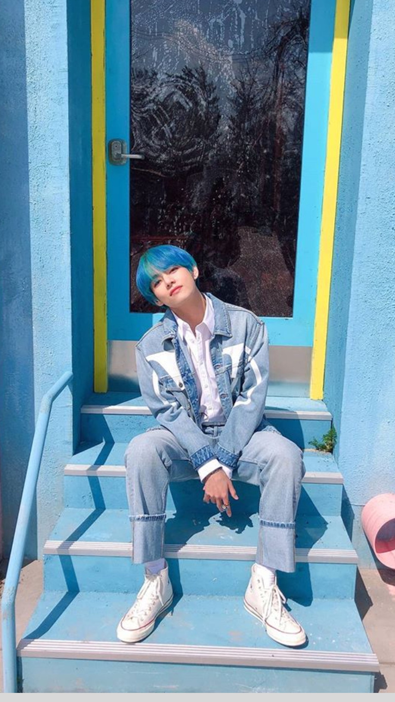 Homem artístico com cabelo azul sentado nos degraus em frente a uma porta azul (bangtan boys, bangtan sonyeondan, boy with love, bts, kim taehyung)