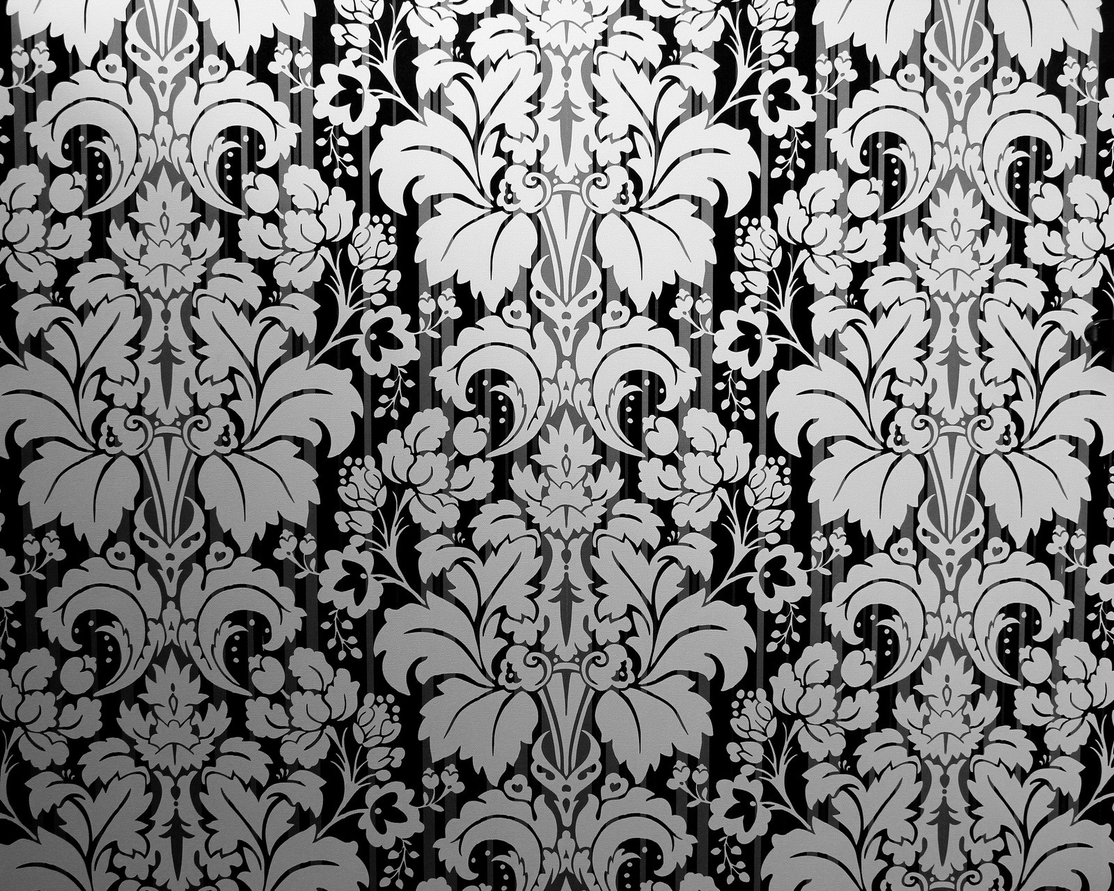 Un primer plano de una pared con un patrón de flores (blanco negro, floral, patrón de flores)