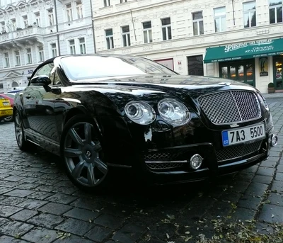 Elegante Bentley GT preto estacionado em rua de paralelepípedos