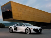 Sleek Audi R8 Sportscar in front of a modern architectural marvel.