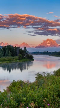 Reflexão do pôr do sol sobre a paisagem serena do Parque Nacional Grand Teton