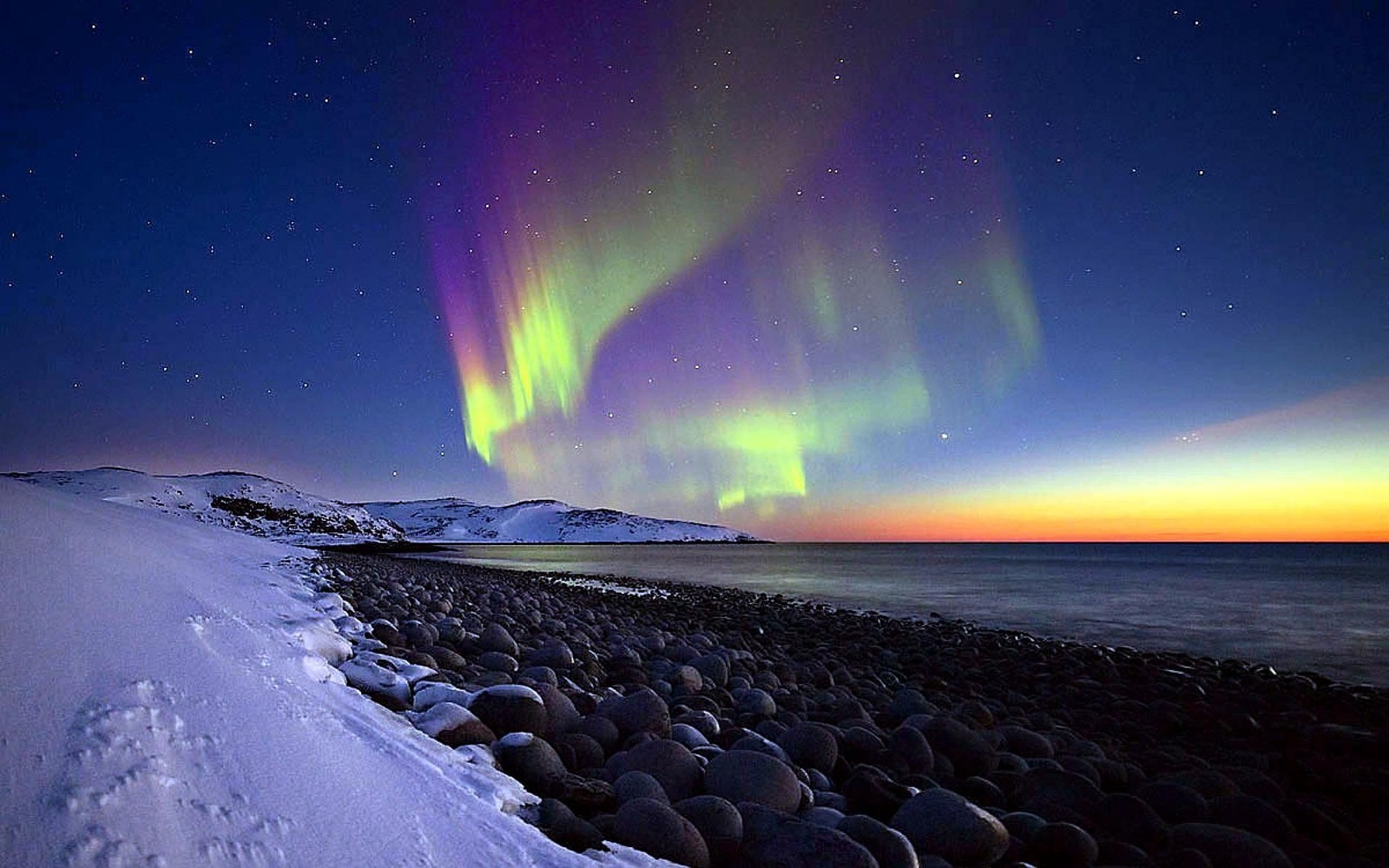 Buntes polarlicht über einem felsigen strand und dem ozean. (aurora, natur, natürliche landschaft, atmosphäre, arktis)