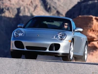 Porsche 911 GT2: A Silver Sports Car in Motion Against a Mountainous Backdrop