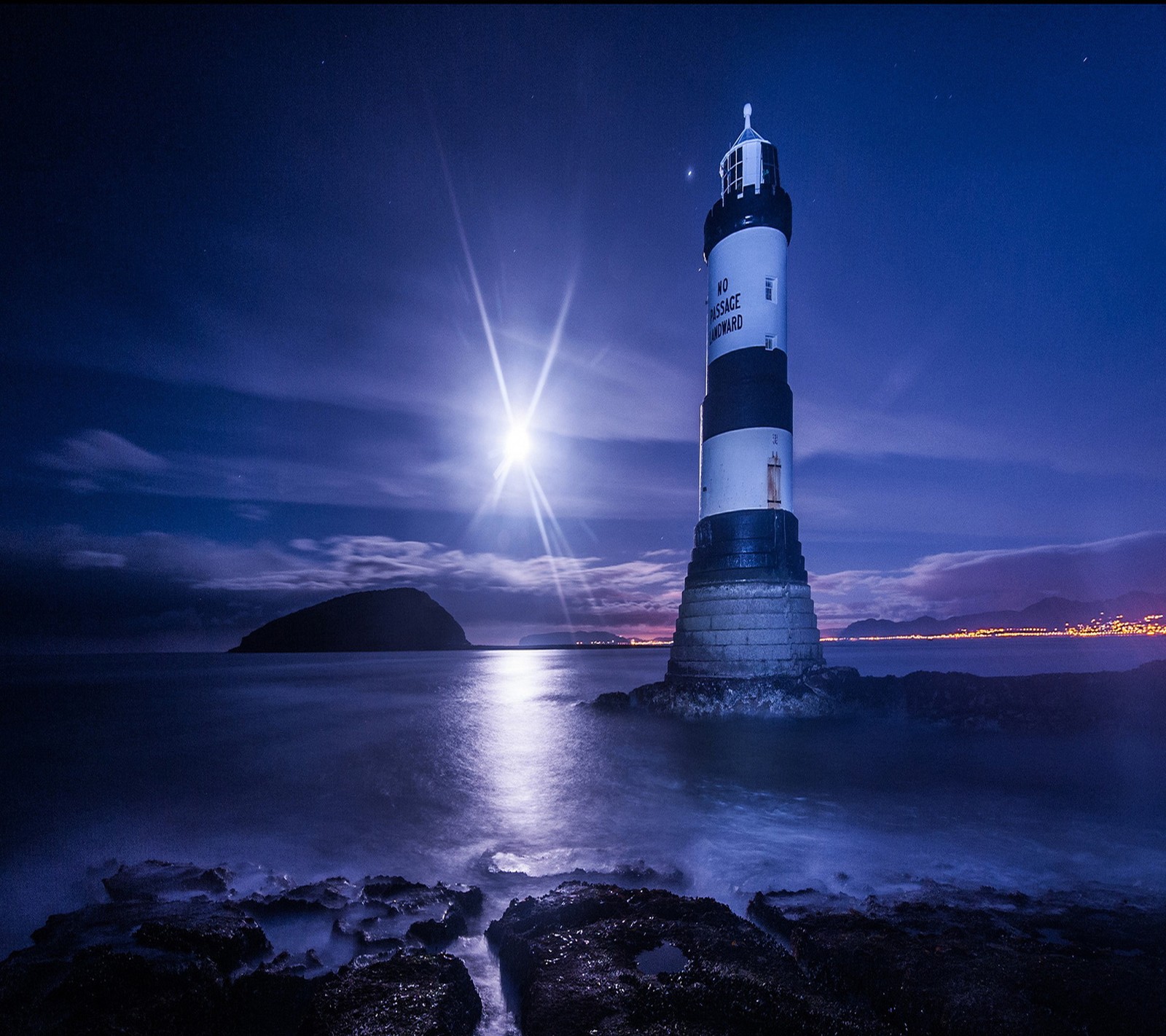 Imagem desfocada de um farol em uma costa rochosa com uma lua cheia ao fundo (farol, papel de parede)