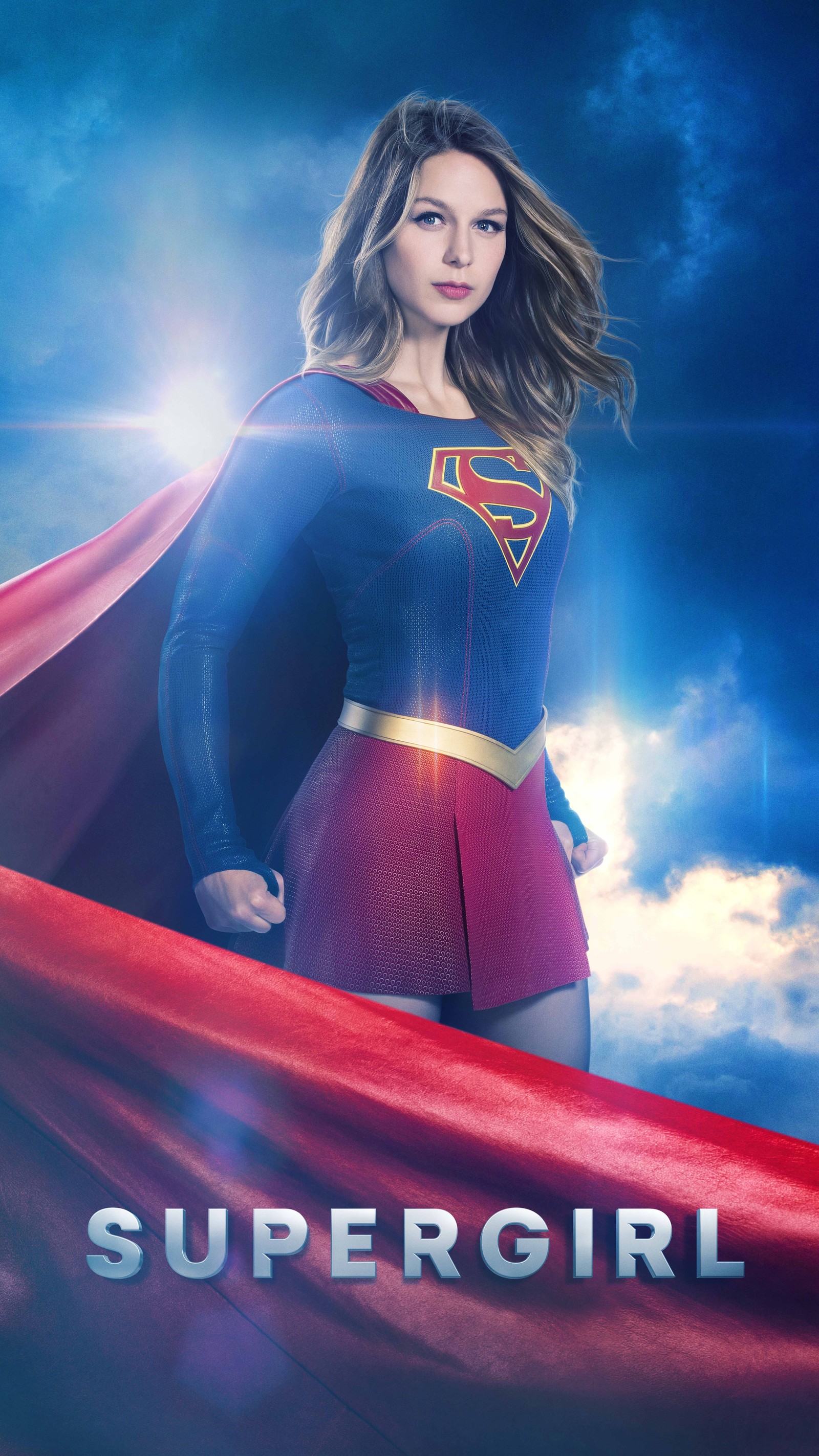 Une femme en costume de superman se tient sur une cape rouge (denvers, kara, supergirl, super héros)