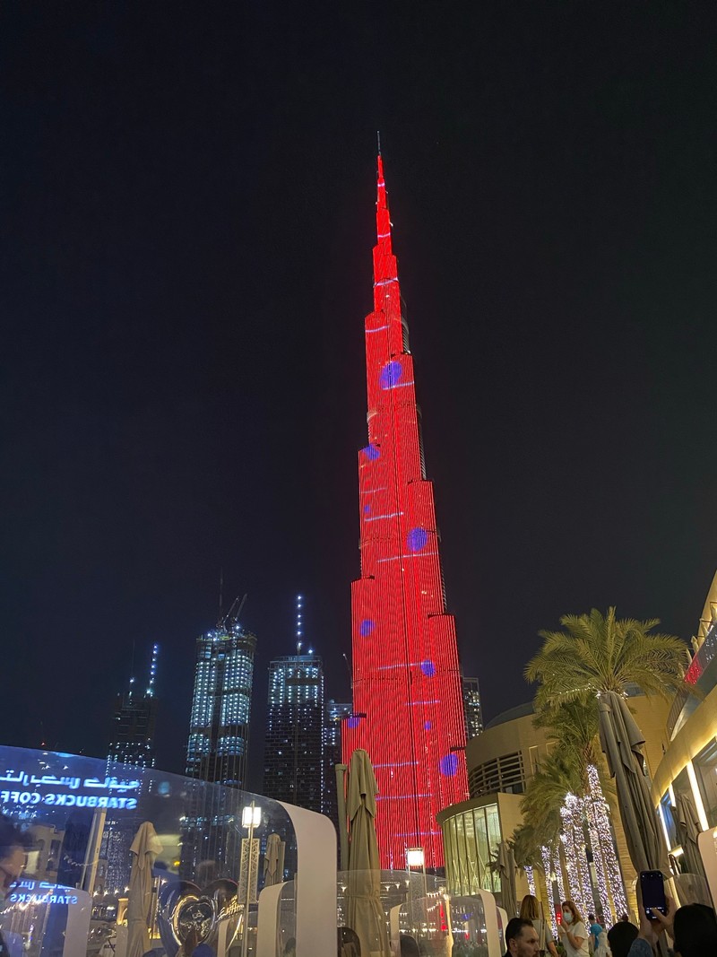 Фасад высокого здания с красной башней, освещенной ночью (дубай, dubai, burj khalifa, небоскреб, рождественская ёлка)