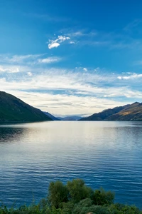 Tranquil Highland Lake at Sunset with Reflective Waters and Mountainous Backdrop