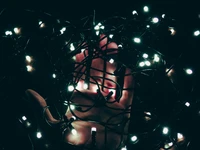 Illuminated Creativity: A Hand Amidst Twinkling Lights