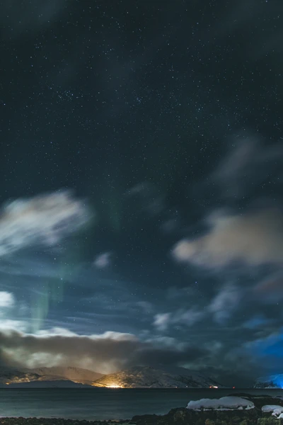 Serener Nachthimmel mit Aurora über ruhigem Meer und sternenklarem Horizont