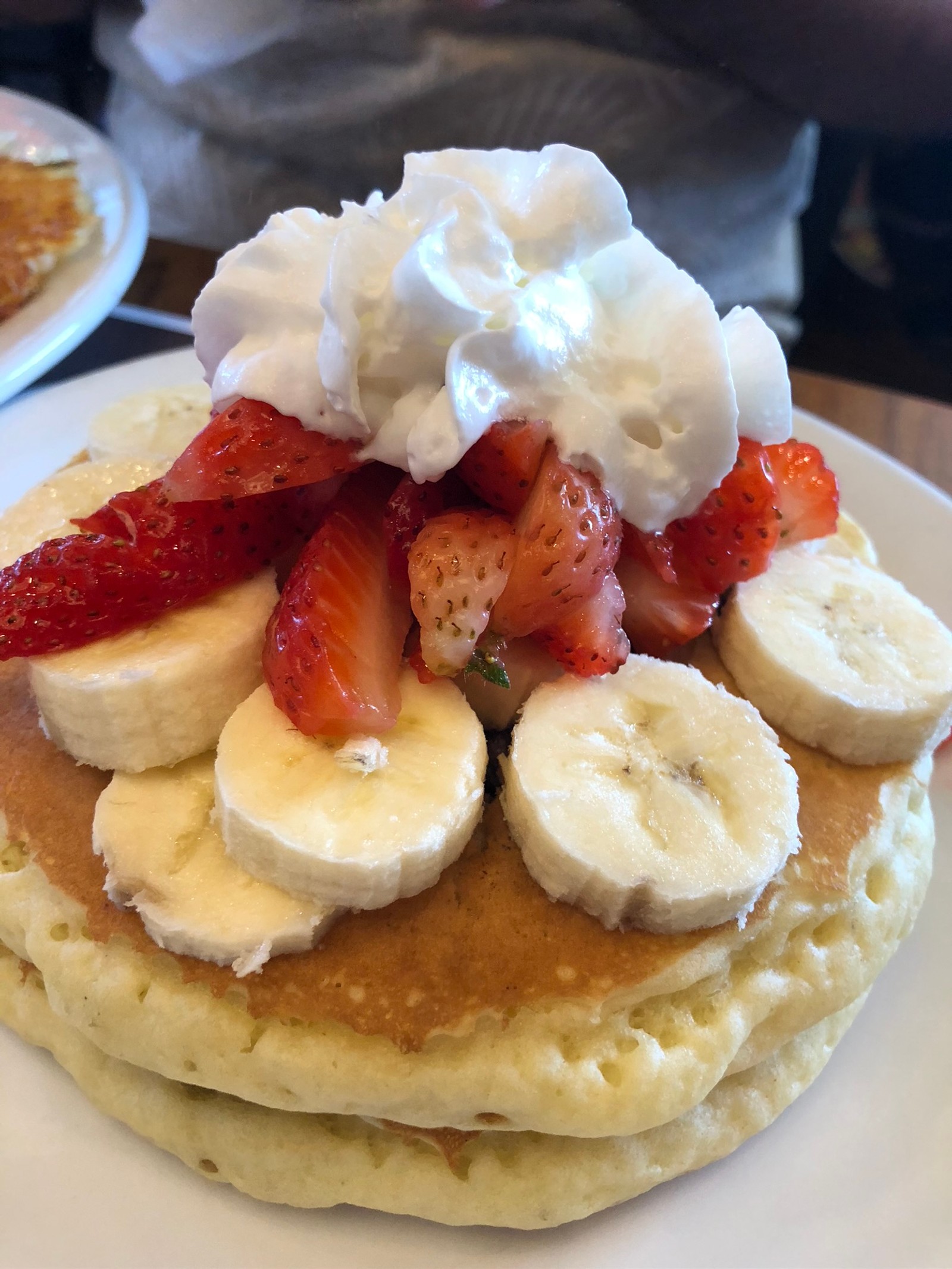 Waffles con fresas, plátanos y crema batida sobre una pila de panqueques (comida, panqueque, desayuno completo, desayuno, fresa)