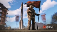 Un personnage en combinaison de protection se tient avec confiance avec un drapeau déchiré devant une fusée imposante et des structures industrielles, incarnant l'esprit de survie du jeu "Rust".