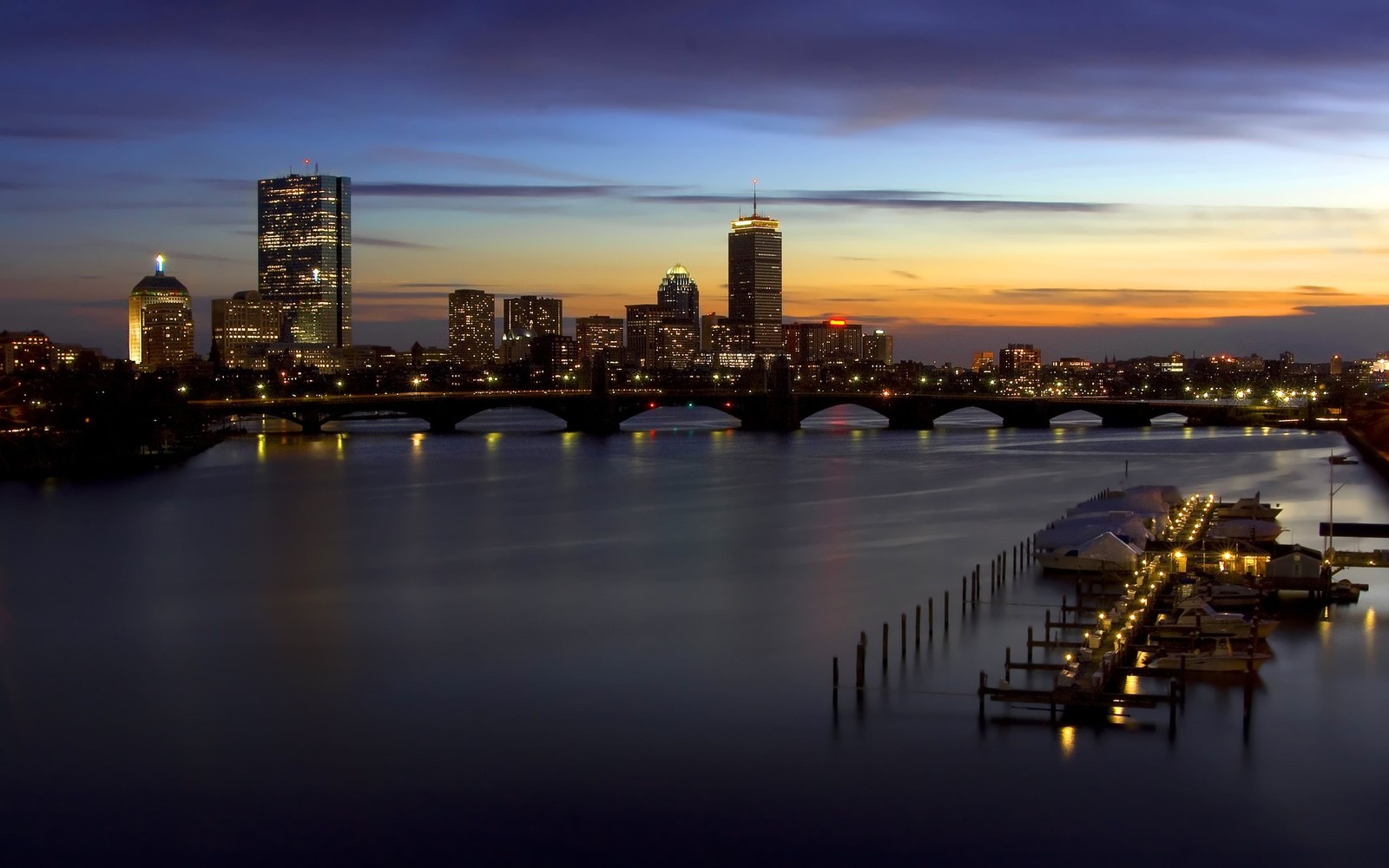 Uma vista árabe do horizonte de uma cidade ao entardecer com barcos atracados na água (paisagem urbana, cidade, linha do horizonte, reflexo, crepúsculo)