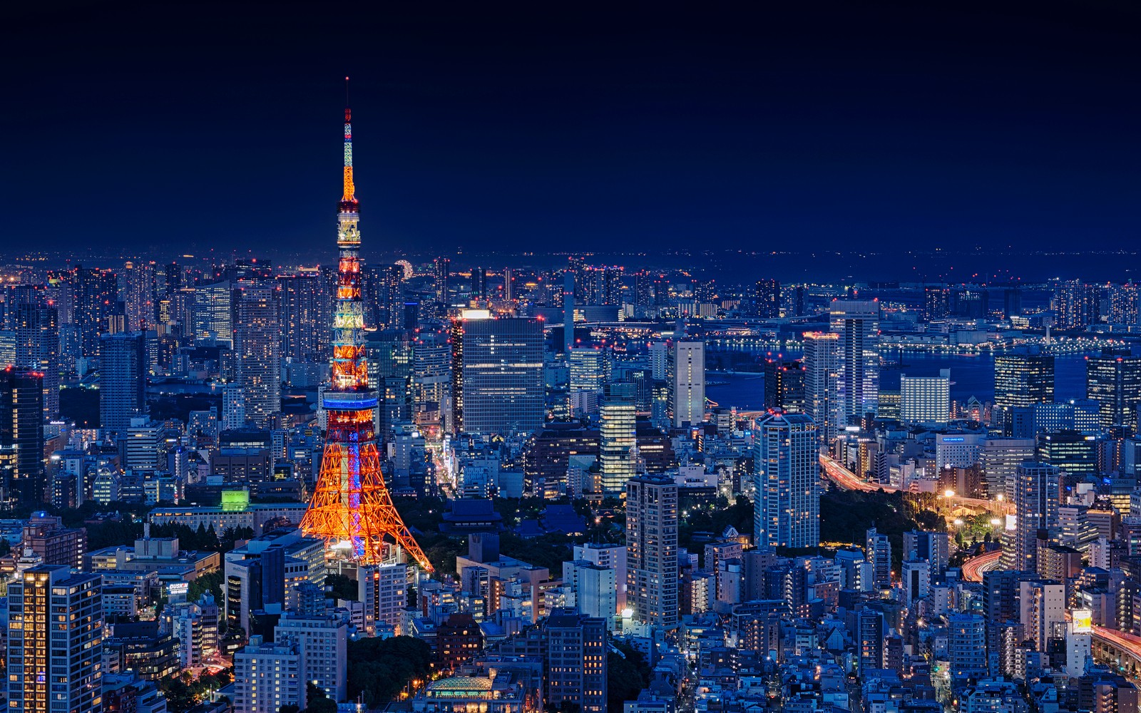 Vista aérea de uma cidade à noite com uma torre alta (torre de tóquio, tokyo tower, japão, estrutura metálica, paisagem urbana)