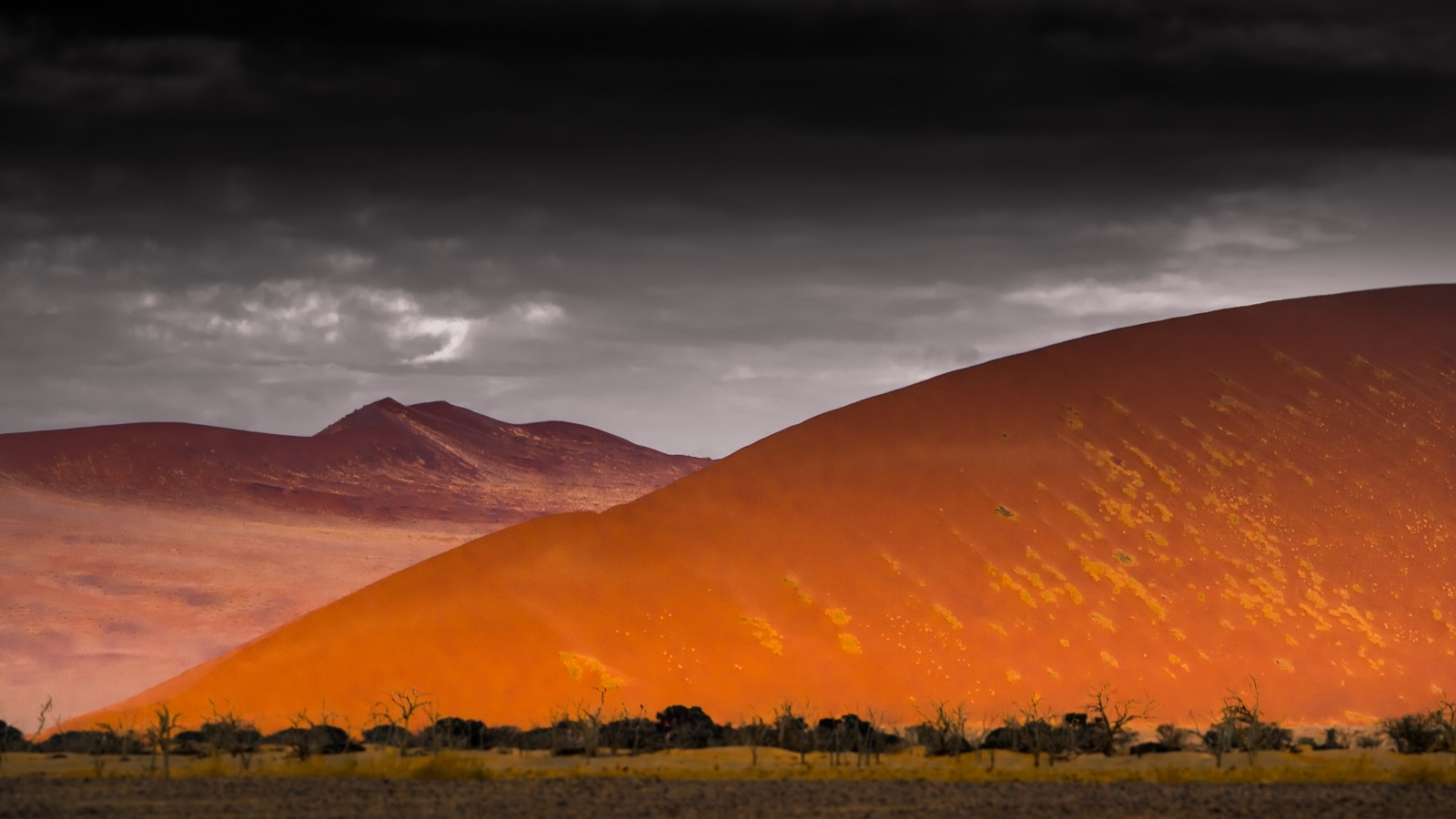 Une grande dune rouge au milieu d'un désert avec un ciel sombre (désert datacama, désert, nature, écorégion, paysage)