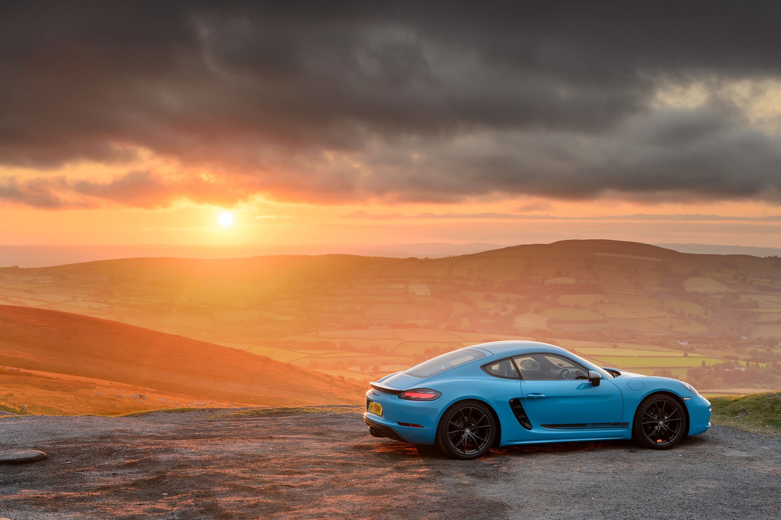 Um carro esportivo porsche azul estacionado em uma estrada com um pôr do sol ao fundo (porsche, carro esportivo, supercarro, paisagem, rei)