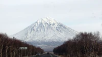 Majestoso estratovulcão cercado por uma paisagem de inverno e céu limpo