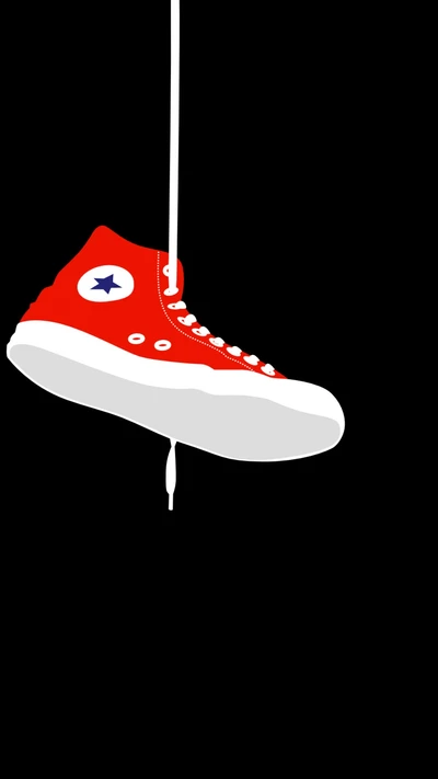 Roter Converse High-Top Schuh, der an einem weißen Schnürsenkel vor schwarzem Hintergrund hängt