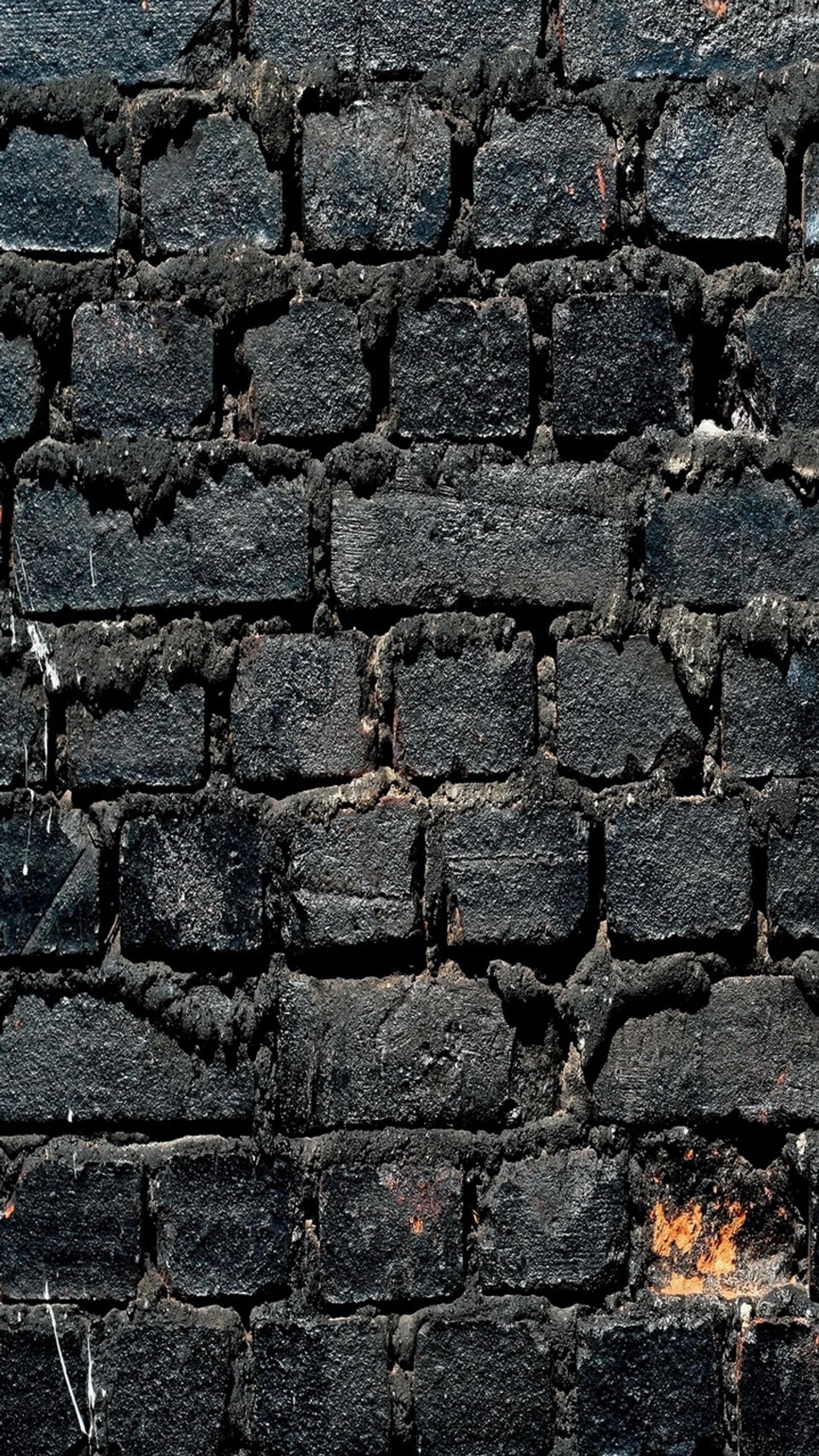 Un primer plano de un hidrante en una pared de ladrillo (negro, ladrillo, pared)