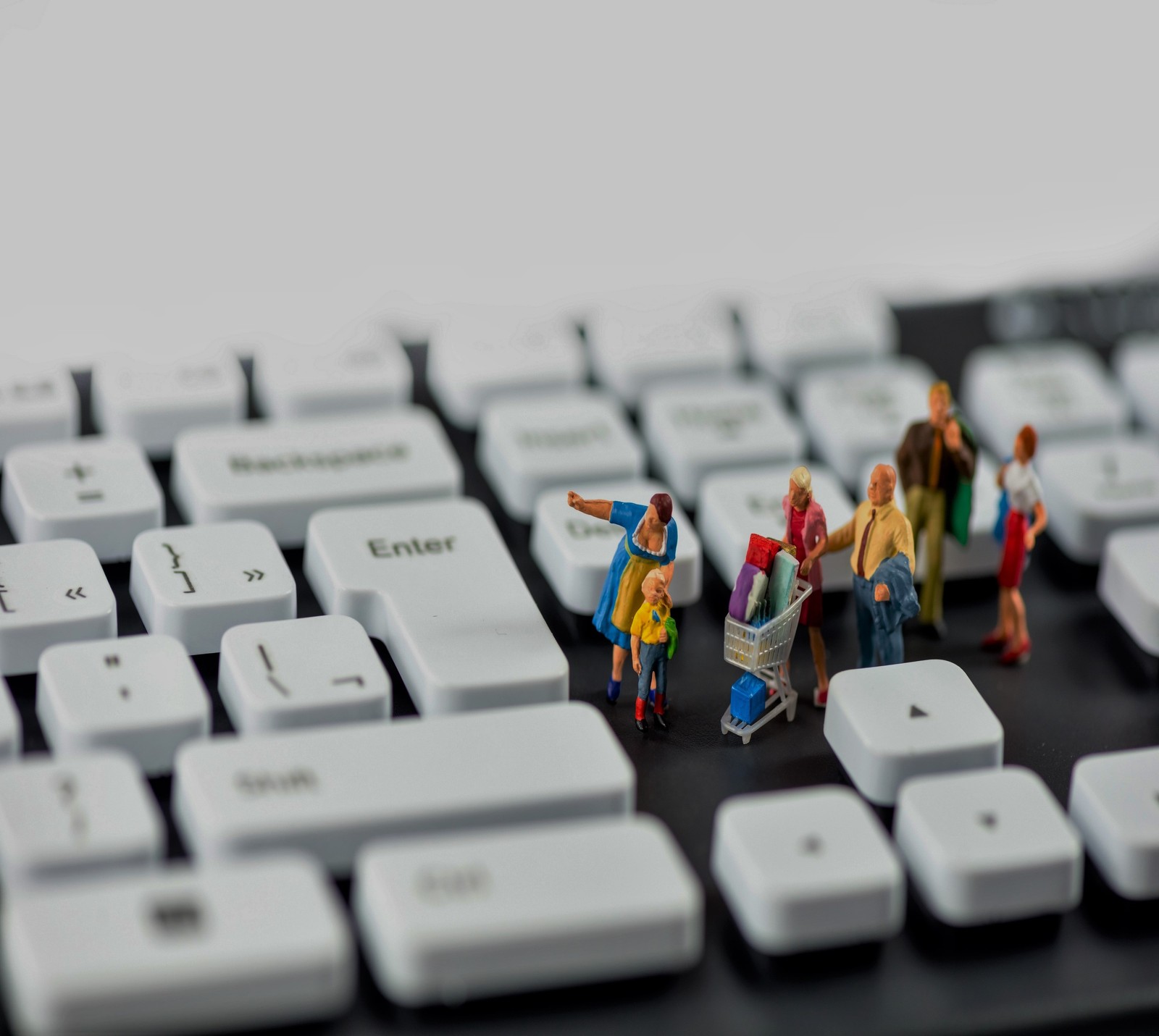 Il y a de petites figurines de personnes debout sur un clavier (abej, beograd, famille, clavier, shopping)