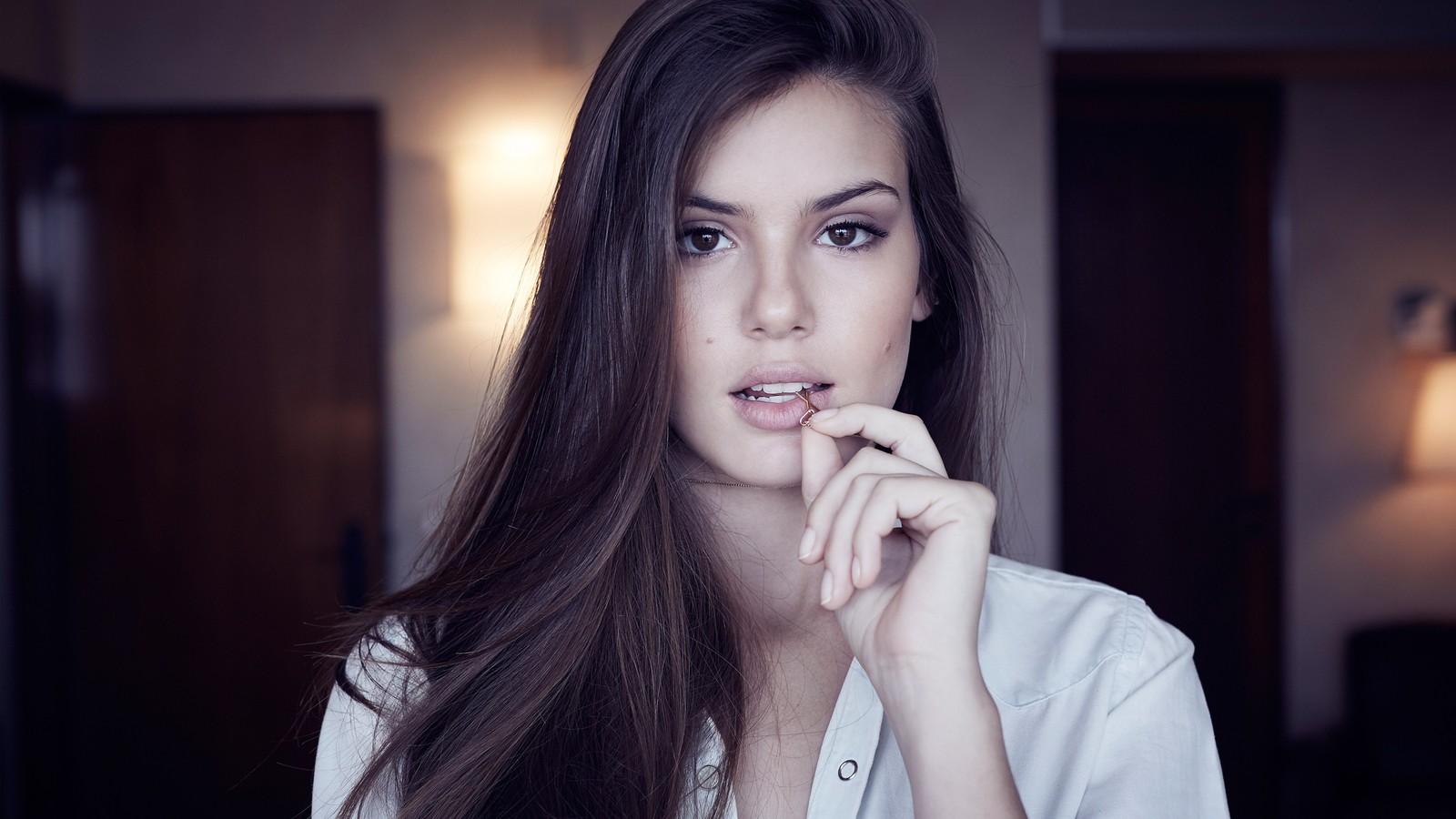 Vue aérienne d'une femme aux longs cheveux bruns posant pour une photo. (nez, peau, lèvre, sourcil, épaule)