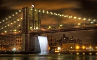 Ponte do Brooklyn iluminada à noite com reflexo de cachoeira