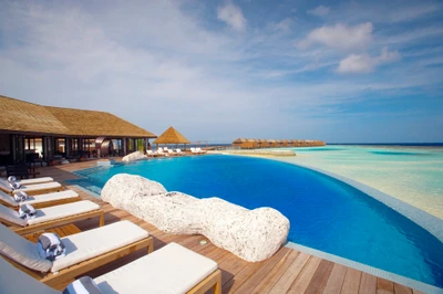 Luxurious beachfront resort with an infinity pool overlooking the Caribbean Sea, offering a perfect vacation retreat.