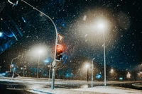 Tráfego em uma noite de neve sob luzes de rua e estrelas