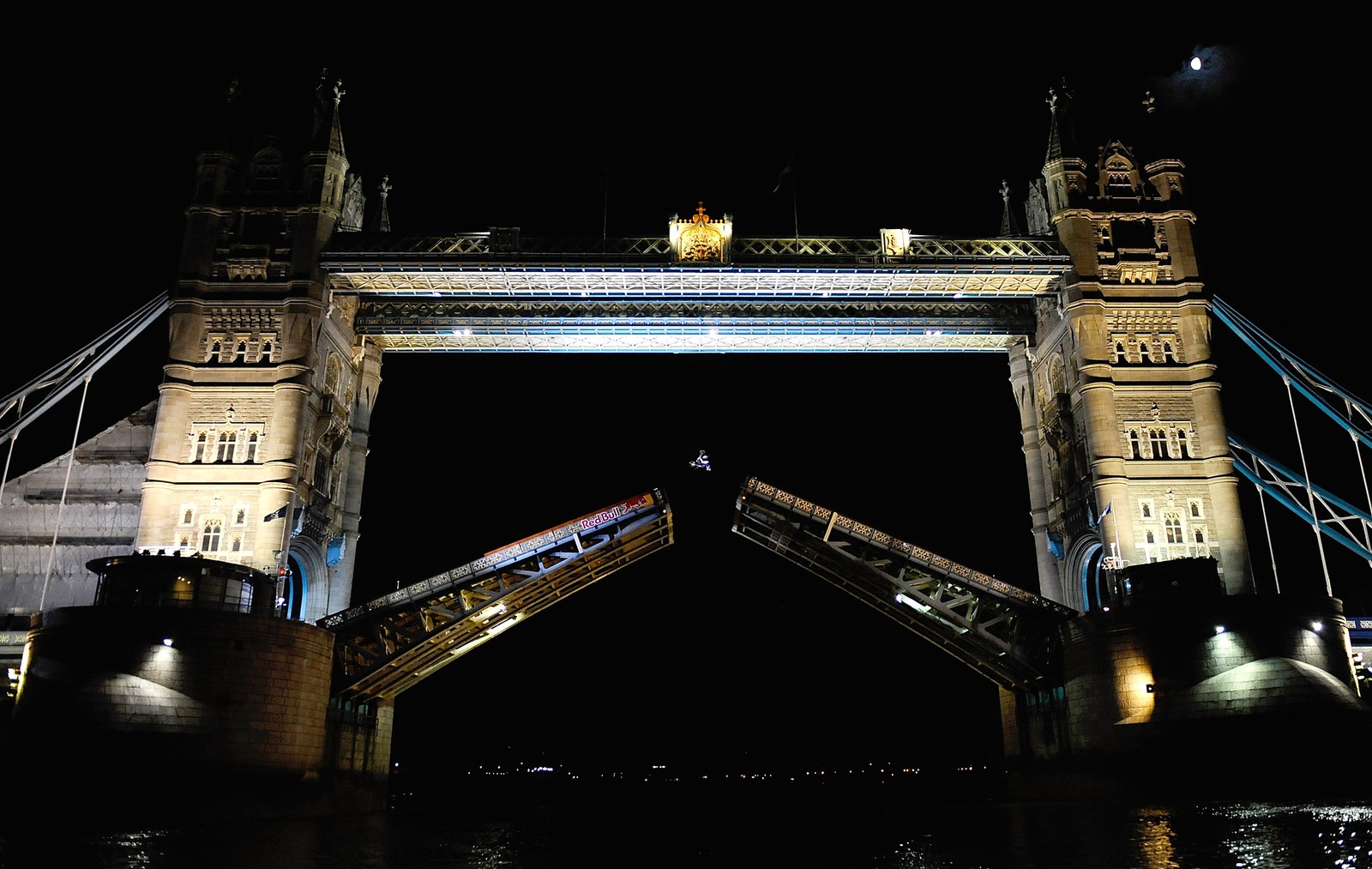 Uma ponte arqueada com um trem passando por ela à noite (tower bridge, torre de londres, motocross estilo livre, noite, arquitetura)