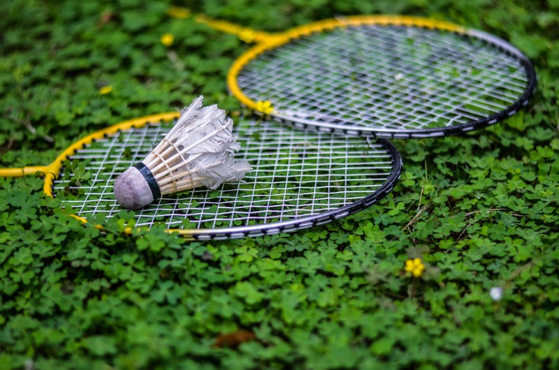 Две ракетки для бадминтона лежат на земле с мячом в траве (бадминтон, badminton, теннис, tennis, ракетка)